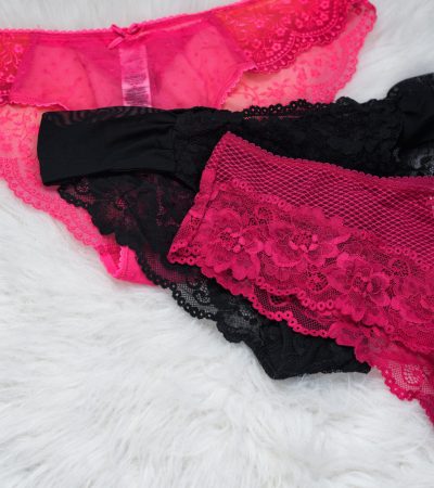 Lace panties of different colors on white fur. Fashionable lingerie concept